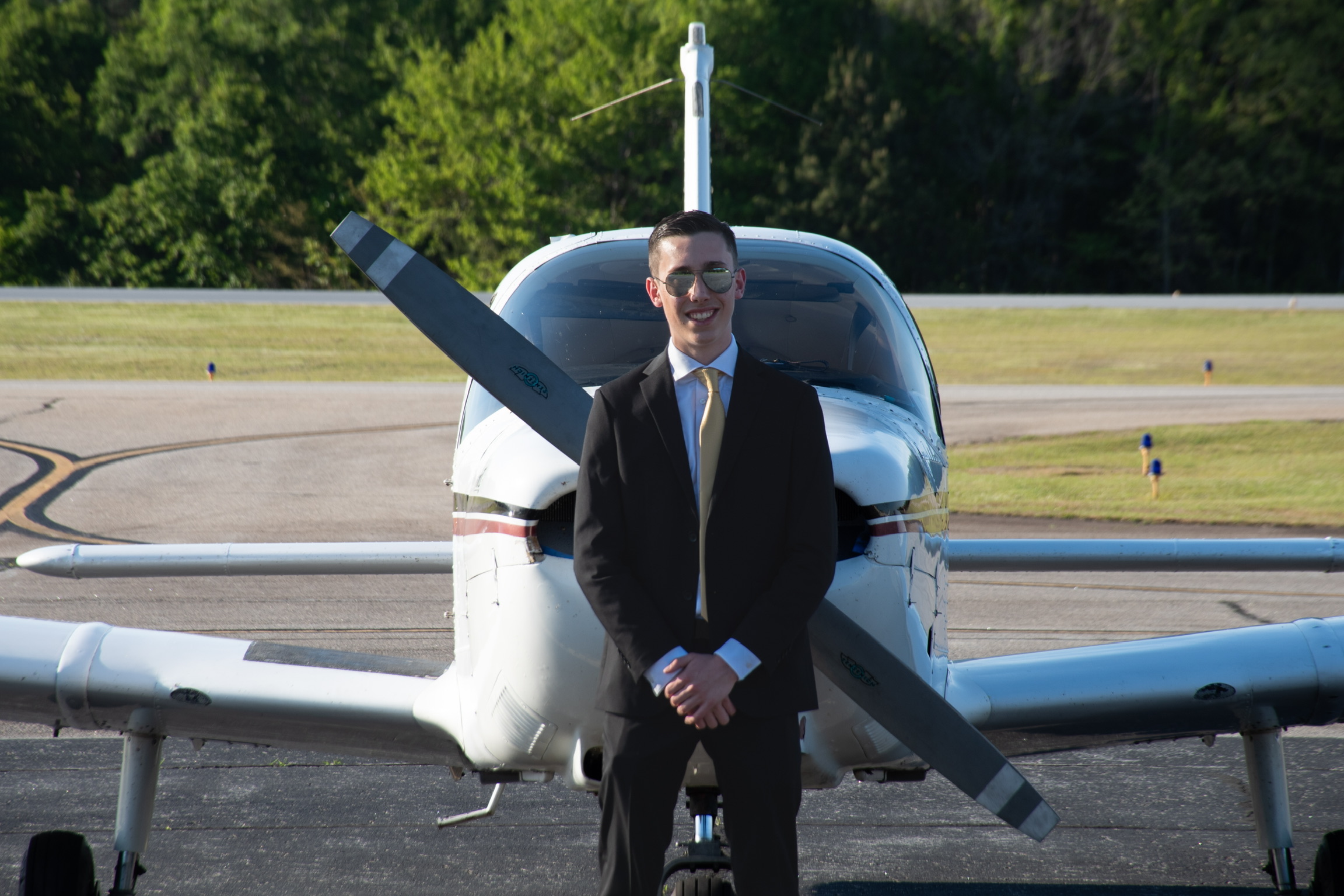 Lincoln Hathaway standing in front of a single-engine airplane